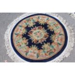 Two similar floral decorated circular Chinese rugs on blue ground (at fault)