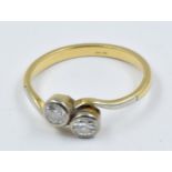 Yellow gold two stone diamond set ring in crossover stlye