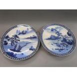 Pair of large late 19th Century Imari blue and white chargers decorated with landscapes, 18ins