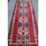 Kurdish rug with a quadruple pole medallion design in shades of red and blue with a triple border,