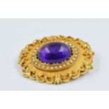 9ct Yellow gold oval cabochon amethyst mounted brooch, surround by split seed pearls 43mm long x
