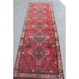 Shiraz runner with a multiple pole medallion and all-over floral and bird design on a red ground