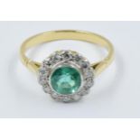 18ct Yellow gold flowerhead ring set with a central circular emerald within a diamond surround