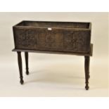 Rectangular carved oak jardiniere decorated with floral carvings and raised on turned tapering