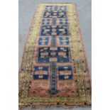 Belouch runner with a triple pole medallion design on a beige ground with green border, 9ft x 3ft