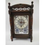 Late Victorian Aesthetic movement mantel clock with a pierced gallery, the ceramic dial flanked by