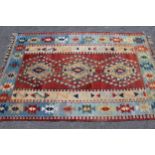 Small Kelim rug with a triple medallion design in shades of iron red, cream, blue and yellow
