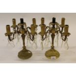 Pair of gilt brass four branch candelabra with cut glass drops and circular bases