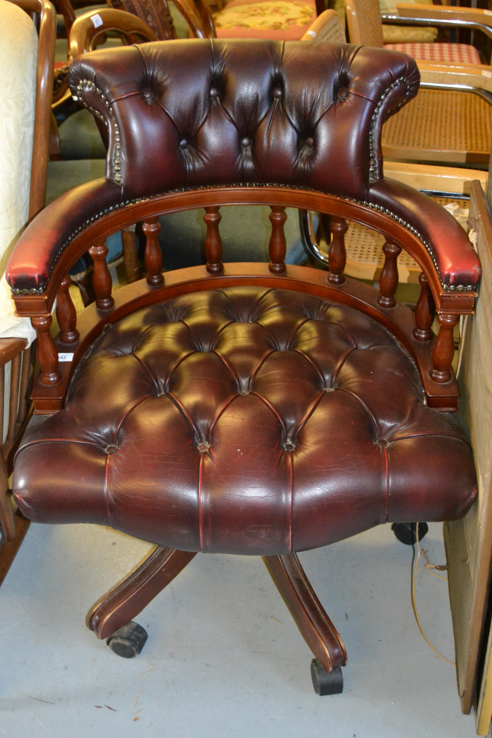 Reproduction mahogany red leather button upholstered office armchair on swept supports and casters