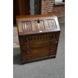 Reproduction oak bureau with three panel fall front above four drawers, together with a similar