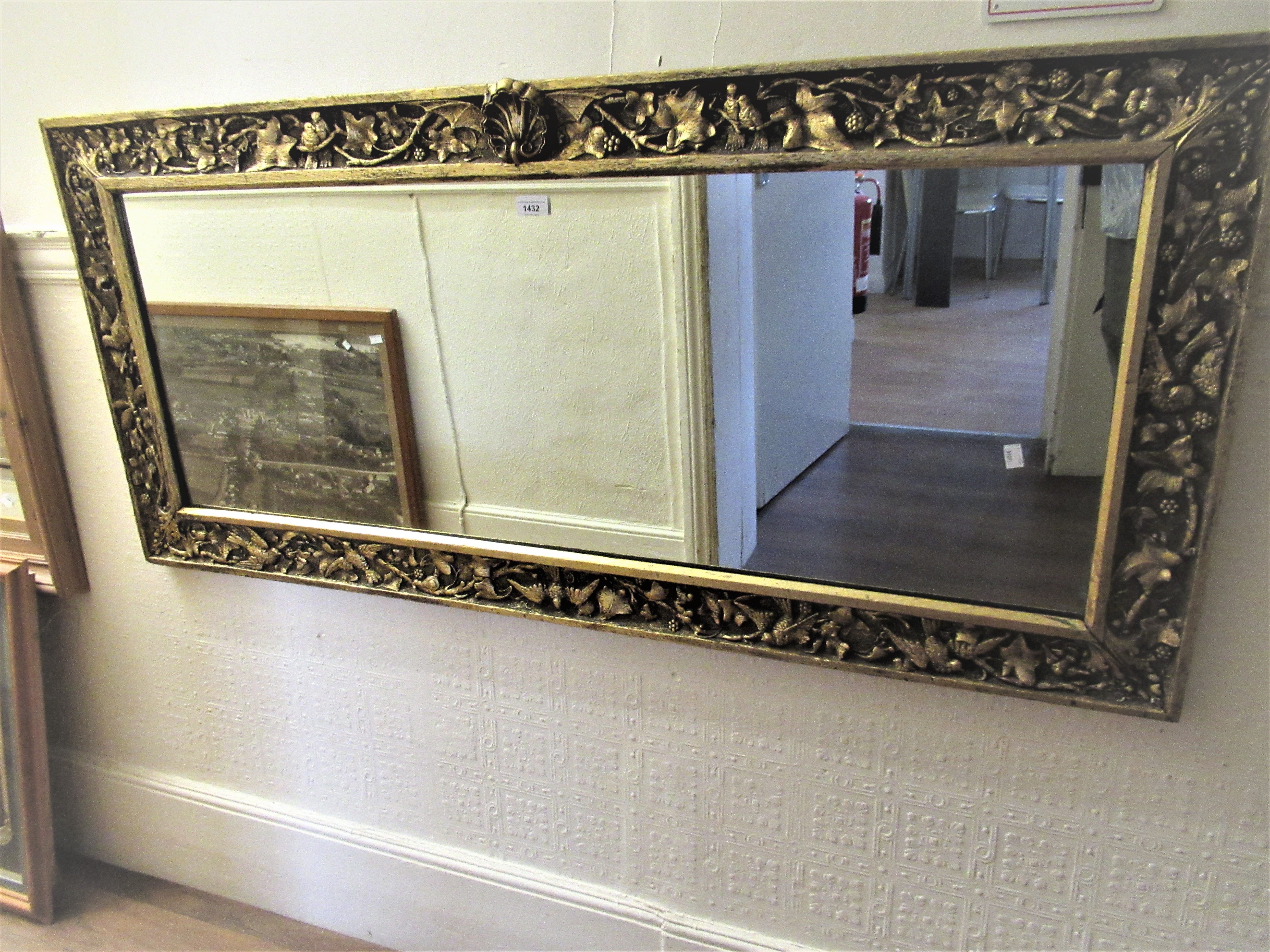 Reproduction carved gilded rectangular wall mirror with shell surmount, 25ins x 55ins