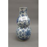Chinese blue and white gourd vase with floral decoration and dual concentric blue rings to base, 7.