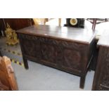 17th / 18th Century oak coffer, the hinged top above a carved frieze and three panel front on