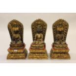 Set of three late 20th Century Chinese carved and pierced figures of Buddha on stands, with gilded