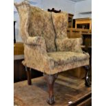 Early 20th Century upholstered wing back armchair in 18th Century style, raised on shell carved