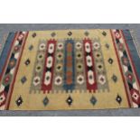 Small flatweave rug with an all-over stylised design on mustard ground, 6ft x 4ft approximately