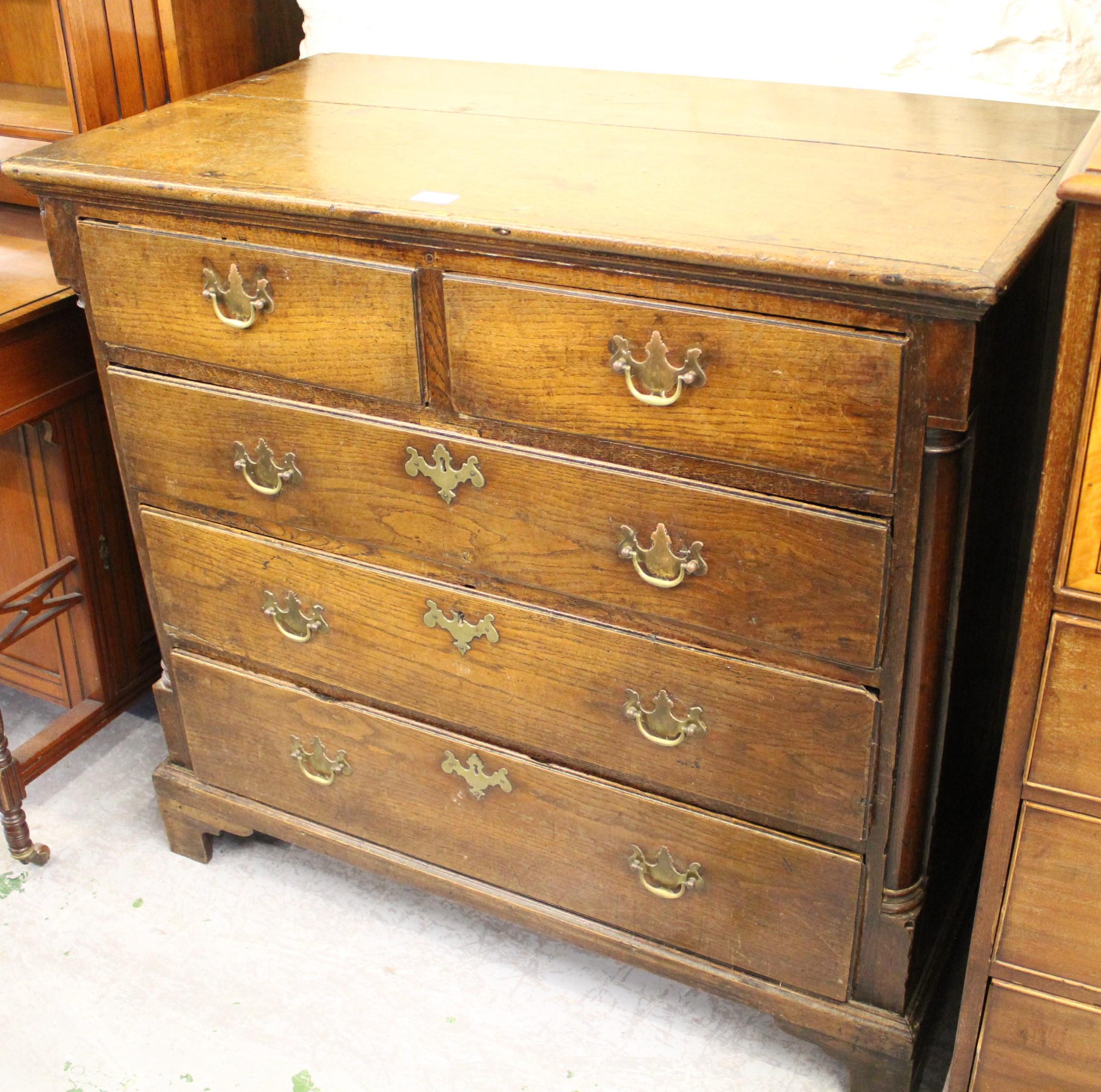 George III oak straight front chest of two short and three long drawers with brass handles,