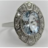 Platinum set Art Deco style ring set with a central oval aquamarine surrounded by diamonds, size O.5