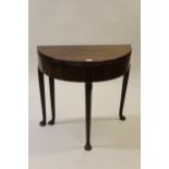 Small 18th Century mahogany half round fold-over tea table on tapering supports with pad feet, 29ins