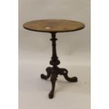 Small Victorian figured walnut and marquetry inlaid oval pedestal table with a carved tripod base,