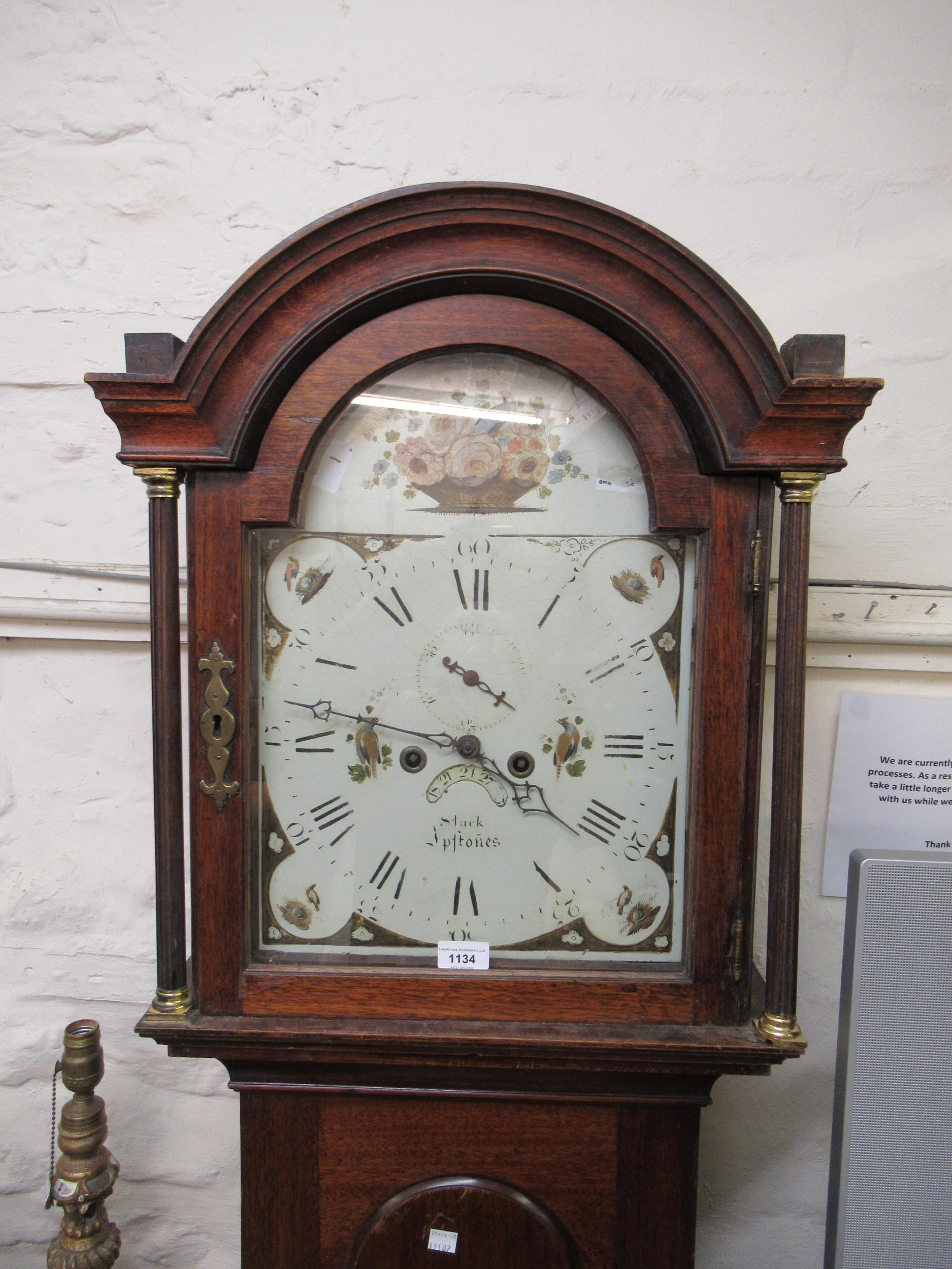 Early 19th Century mahogany longcase clock, the arched hood above an arched panel door, the enamel