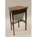 Early 20th Century mahogany sewing table, the shaped hinged top enclosing a fitted interior with