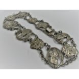 Continental silver necklet with various cast mask head and figure motifs