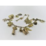 9ct Gold charm bracelet with multiple charms and two loose charms, 18g gross, together with a 9ct