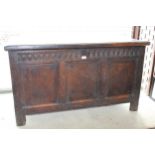 17th Century oak coffer, the hinged moulded plank lid above a carved frieze and three panel front on