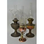 Brass oil lamp with a clear glass shade and chimney, another brass oil lamp minus shade and