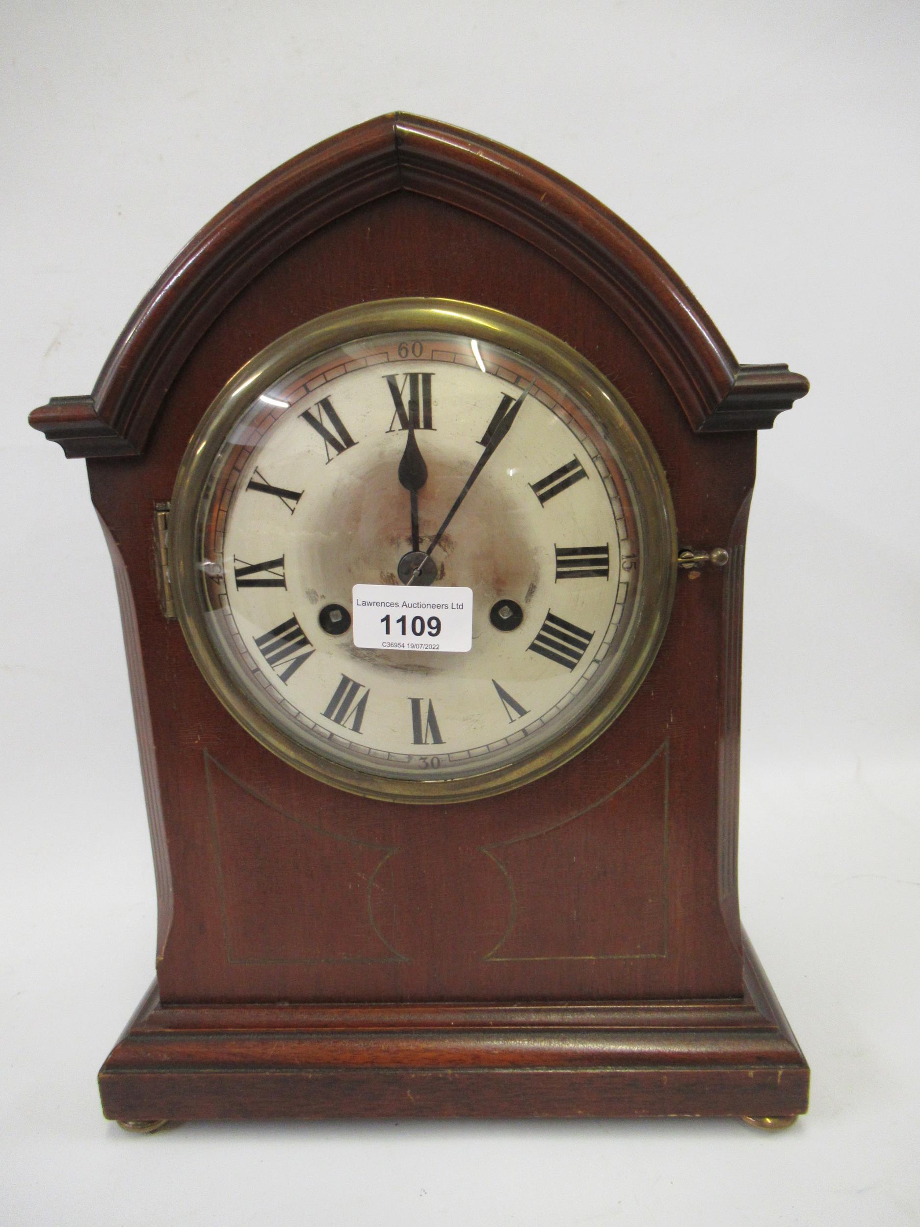 Early 20th Century mahogany arched top mantel clock, the silvered dial with Arabic and Roman