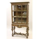 Early 20th Century walnut and parcel gilt display cabinet in 18th Century style, the carved and