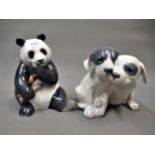 Royal Copenhagen figure of a panda, 6.5ins high together with a similar group of two puppies, 5.5ins