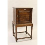 Small 18th Century oak cabinet on stand with a single fielded panel door enclosing four drawers on