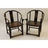 Pair of Chinese hardwood horseshoe elbow chairs with slatted backs, shaped arms and panel seats