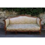 19th Century French walnut and damask upholstered sofa, the floral carved back with scroll arms,