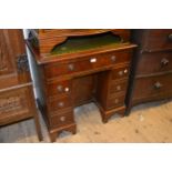 Small reproduction mahogany kneehole desk with a green leather inset top, 30ins wide