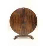 William IV circular rosewood centre table, the tilt top above a tulip carved and fluted column