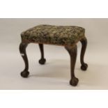 Mahogany stool in 18th Century style, the stuffover seat above shell carved cabriole claw and ball