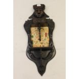 Early 20th Century figural carved hardwood wall bracket inset with an embroidered panel, inscribed