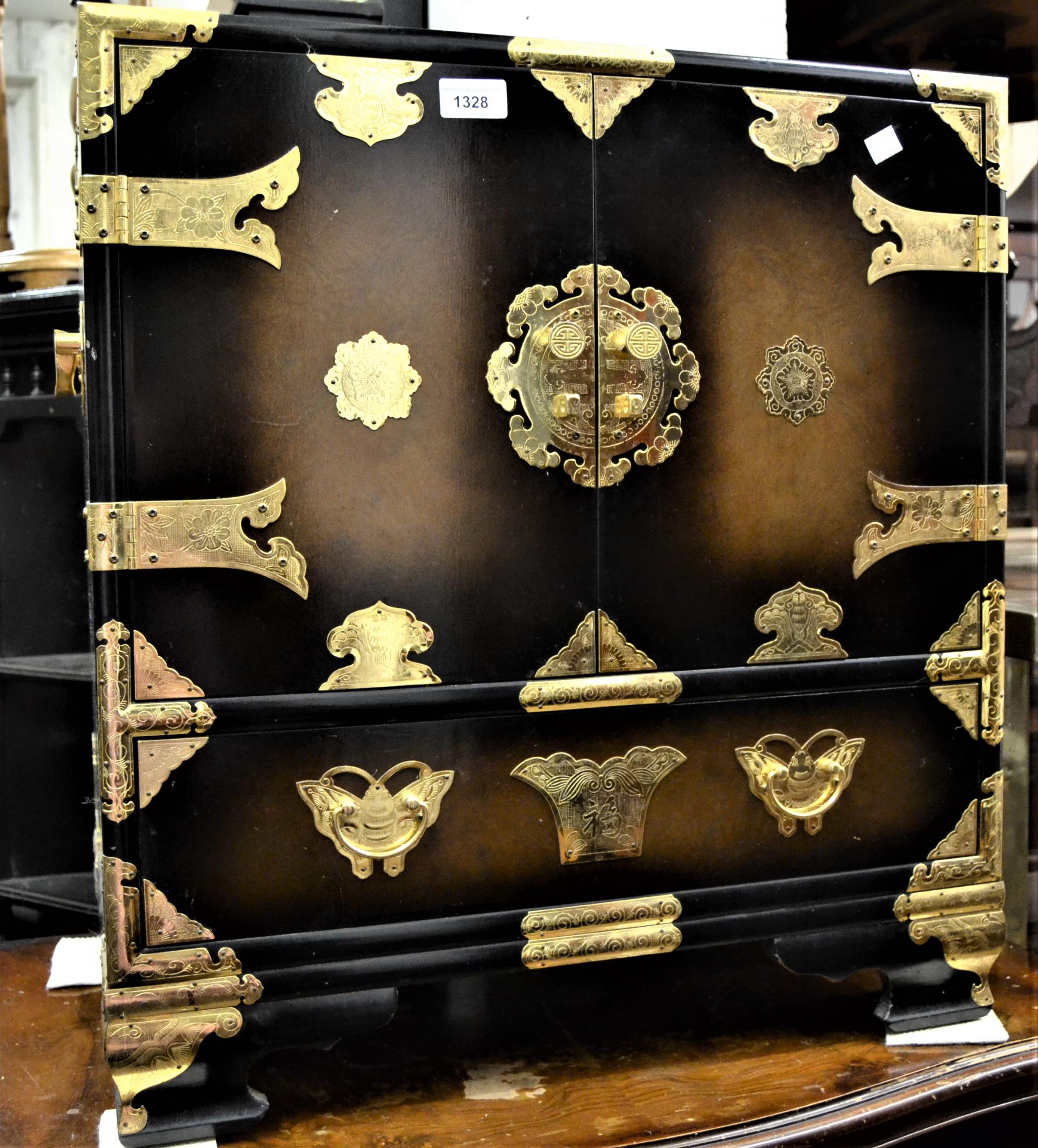 Small lacquer and brass mounted cabinet, the two doors enclosing three small drawers above a further