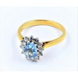 18ct Yellow gold oval blue stone and diamond cluster ring, the central oval blue sapphire bordered