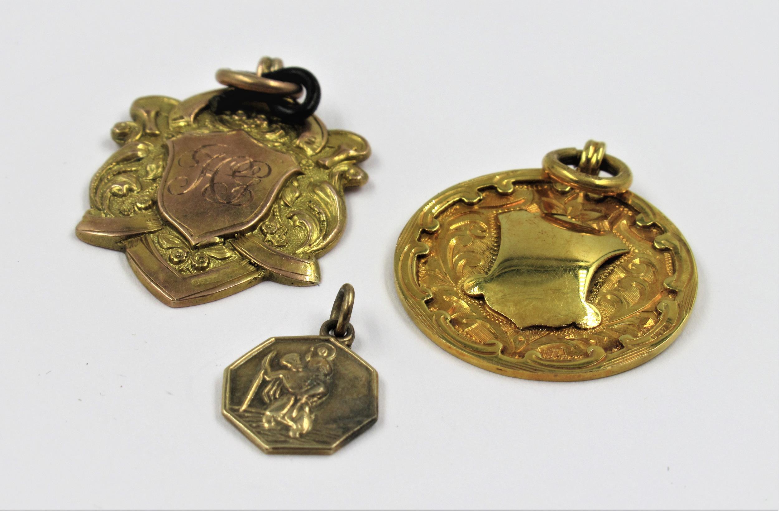 Two 9ct gold sporting medallions and a small St. Christopher, 12g