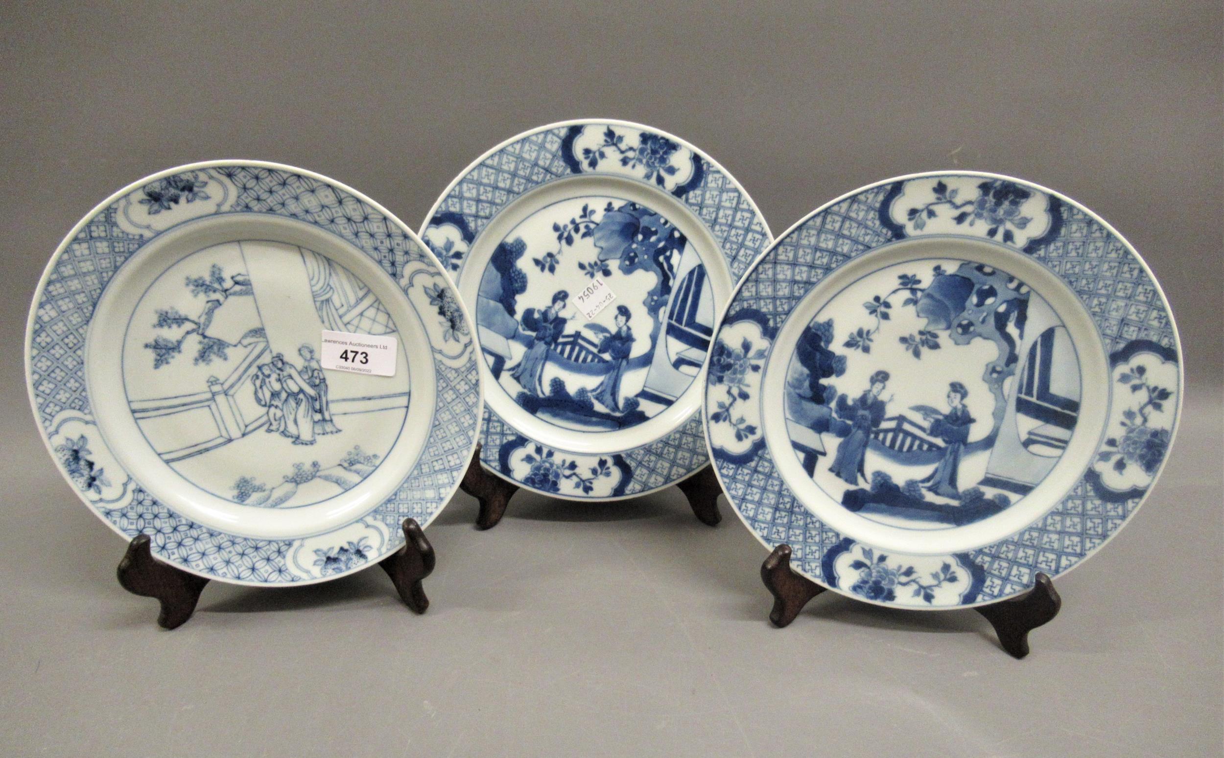 Pair of modern Chinese blue and white plates decorated with figures on a terrace, six character mark