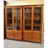 Pair of 20th Century Chinese hardwood bookcases, each with two glazed doors above two floral