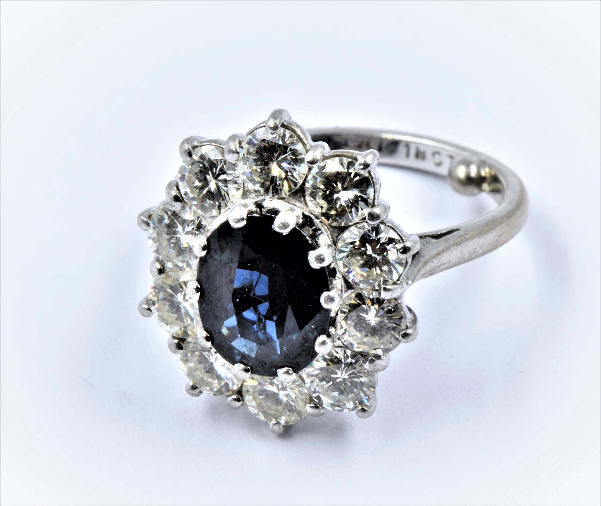 Large 18ct white gold and platinum oval sapphire and diamond cluster ring, the central sapphire