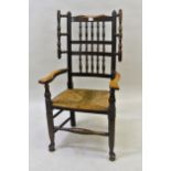 Oak and elm Lancashire spindle back wing chair with rush seat, on turned supports with pad feet