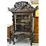 19th Century Japanese carved hardwood and lacquered display cabinet, the moulded cornice with carved