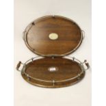 Two Edwardian oak and silver plate mounted drinks trays, the largest 20ins wide
