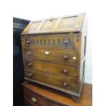 Reproduction oak bureau with three panel fall front above four drawers, together with a similar